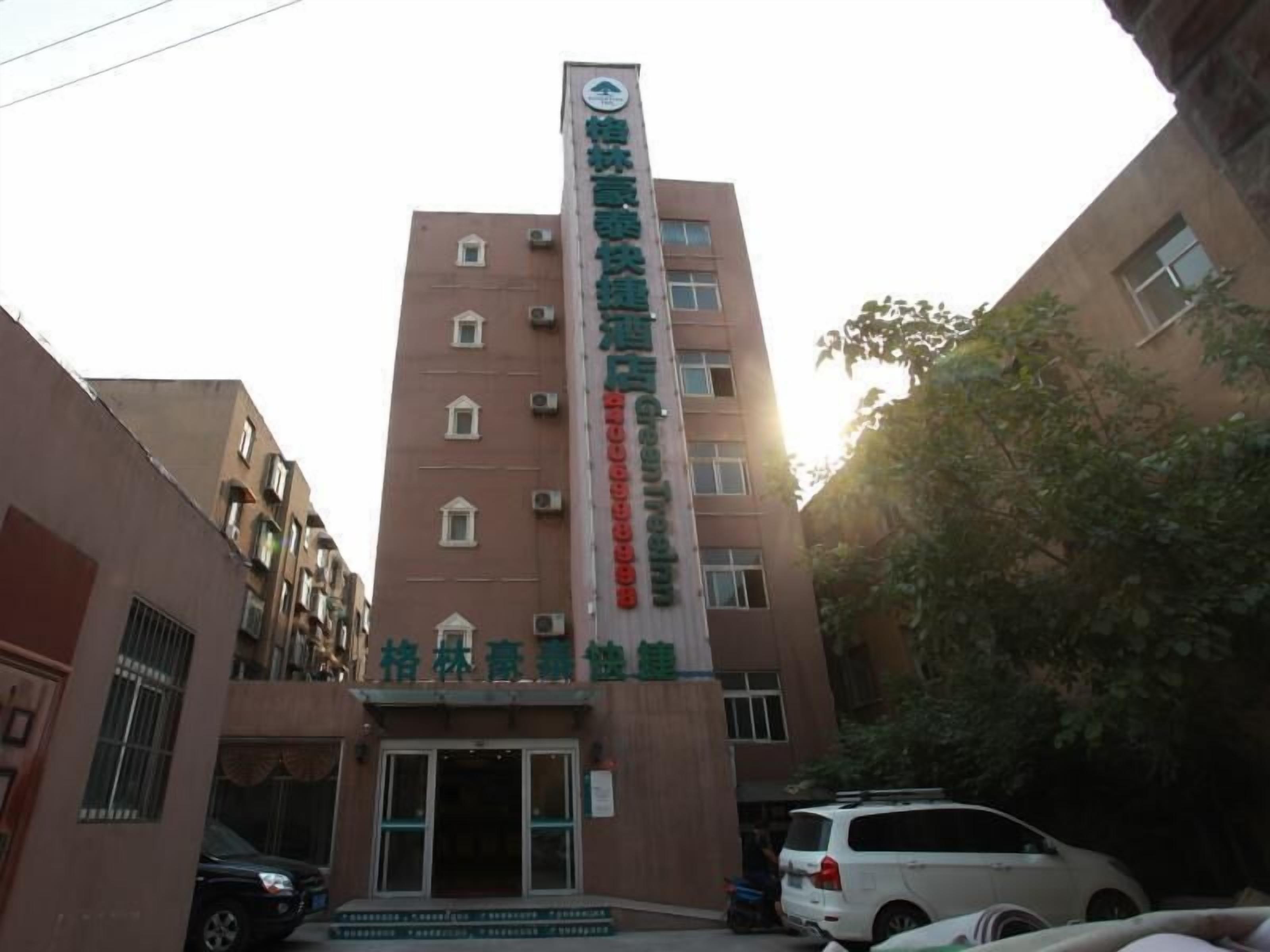 A multi-story building with a vertical sign displaying text.