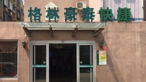 A hotel entrance with a sign above the doors and a small sign on the wall to the right. - Greentree Inn Jinan Tianqiao District Railway Station Square Express Hotel (Jinan)