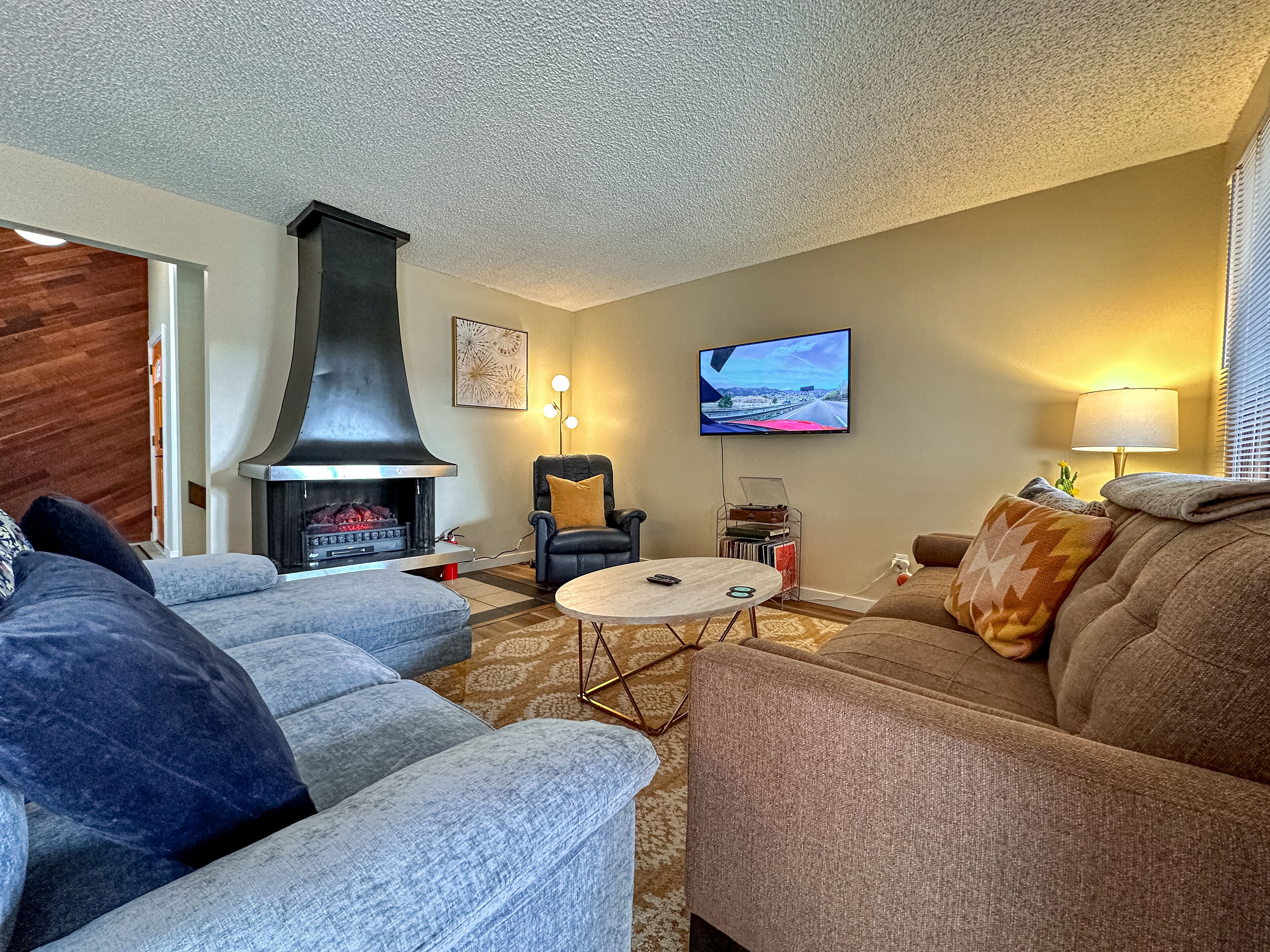 A living room with a fireplace, a television, and a comfortable seating area.