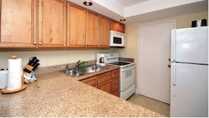 A kitchen with wooden cabinets, a microwave, an oven, and a refrigerator. - FLBR 1 BR Condo 1501 - 2 blocks off beach with great Ocean Front Balcony Views. (Fort Lauderdale)