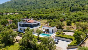 A modern two-story house with a swimming pool, surrounded by lush greenery and hills. - Luxury Villa Perfecta with Pool (Labin)