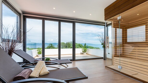 A modern balcony with a view of the sea, equipped with lounge chairs and a wooden wall. - Luxury Villa Perfecta with Pool (Labin)