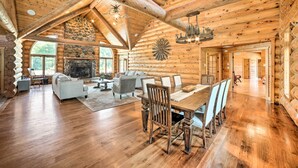 L’intérieur d’une cabane en rondins comprend un coin repas, une cheminée et un mur en pierre.