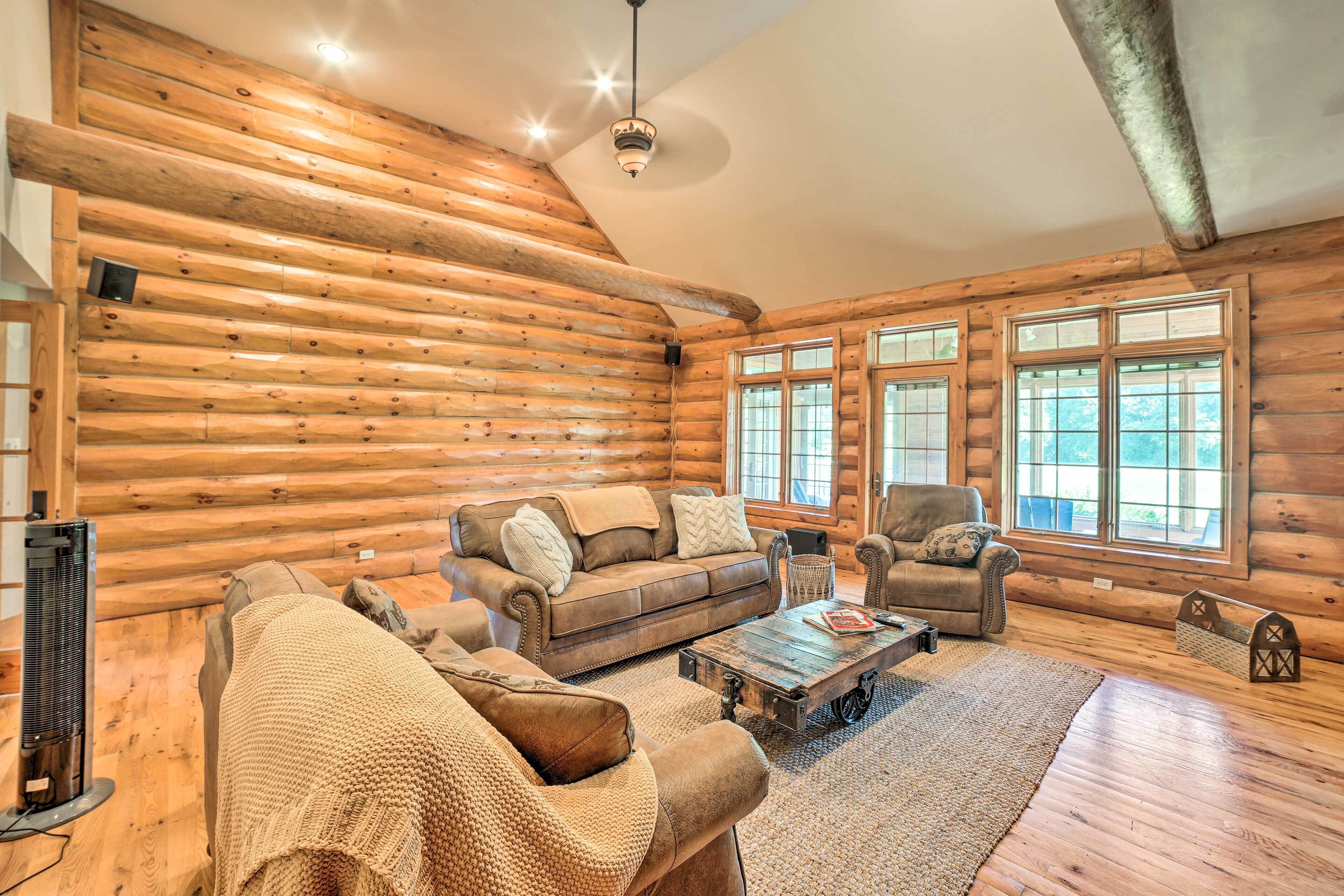 A log cabin interior with a wooden floor, a sofa, a coffee table, and a fireplace.