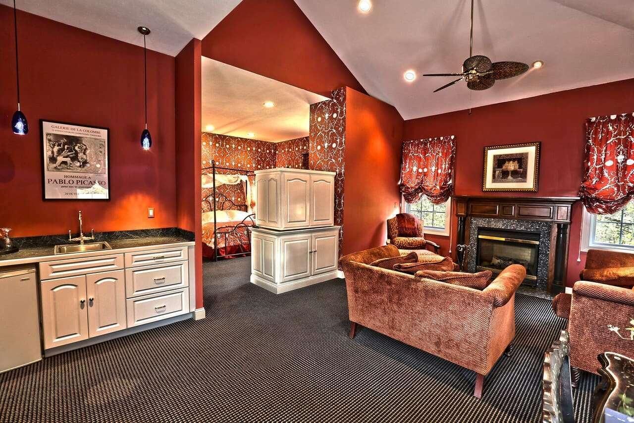 A room with a fireplace, a sofa, a cabinet, and a ceiling fan.