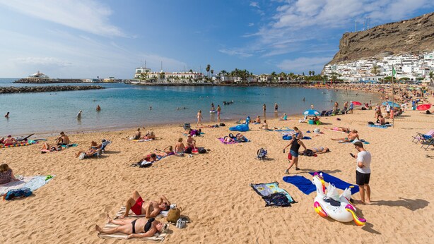 A crowded beach with people sunbathing and swimming. - 20 meters from the beach, private parking and AC (Mogán)