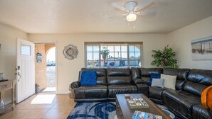 A living room with a leather sectional sofa, a coffee table, and a ceiling fan. - Mescal Loop Hava-Gataway (Lake Havasu City)