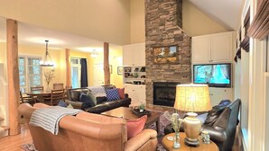 A living room with a fireplace, leather sofas, a television, and a dining area with a chandelier. - Private Echota home, great resort amenities, 2car garage, near best attractions (Boone)