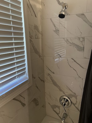 Tina con regadera, toallas, papel de baño