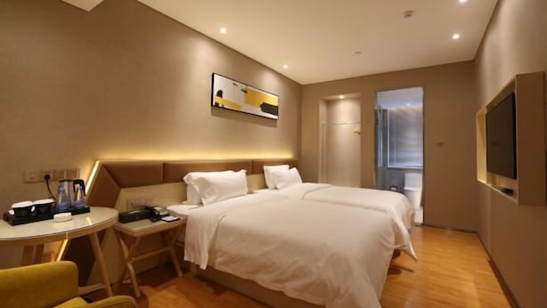 A hotel room with a bed, bedside table, chair, and a TV on the wall. - Boke Hotel Guangzhou Zhujiang New Town (Guangzhou)