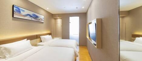 A hotel room with two beds, a large mirror, a painting on the wall, and a TV.
