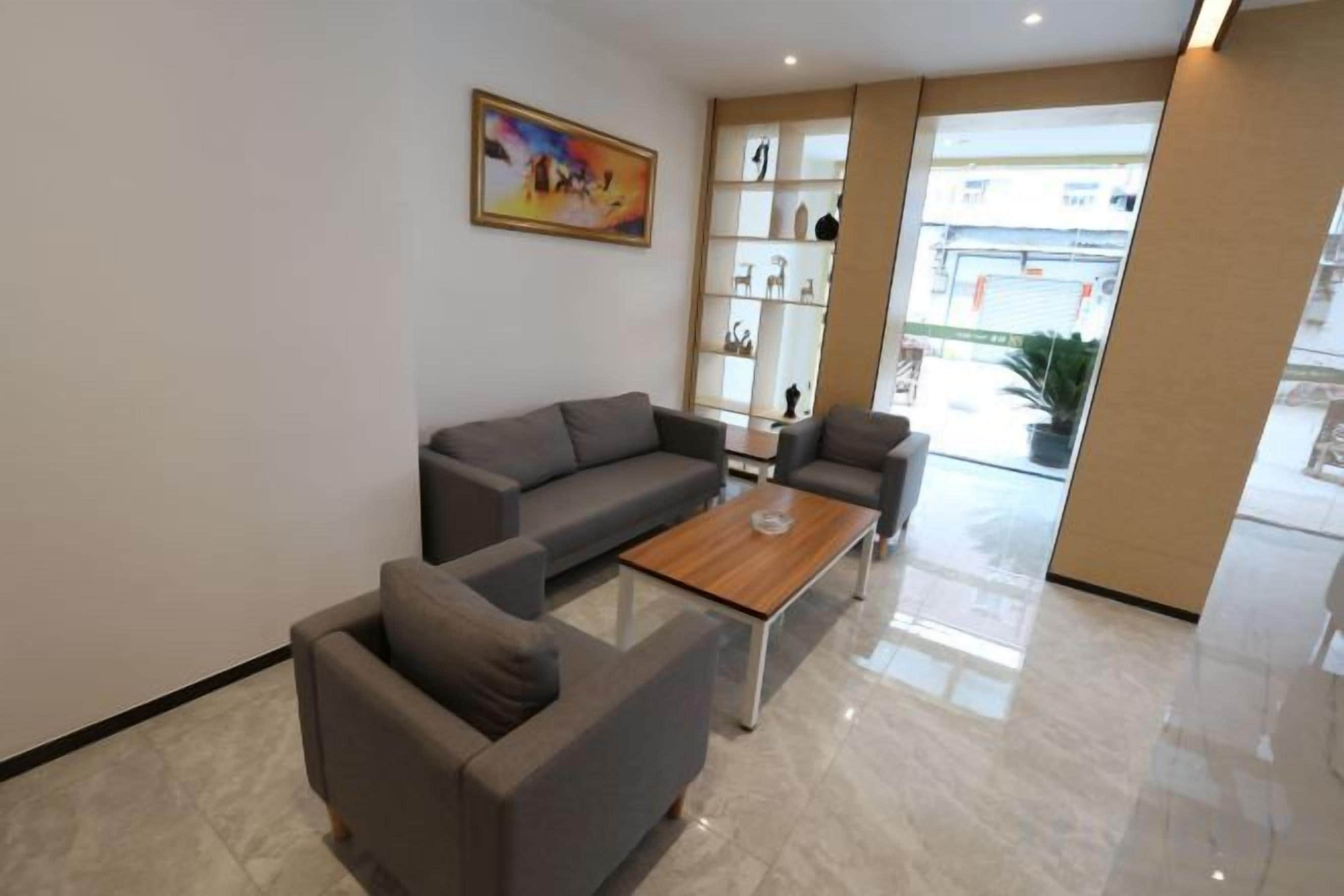 A modern living area with a sofa set, a coffee table, and a bookshelf.