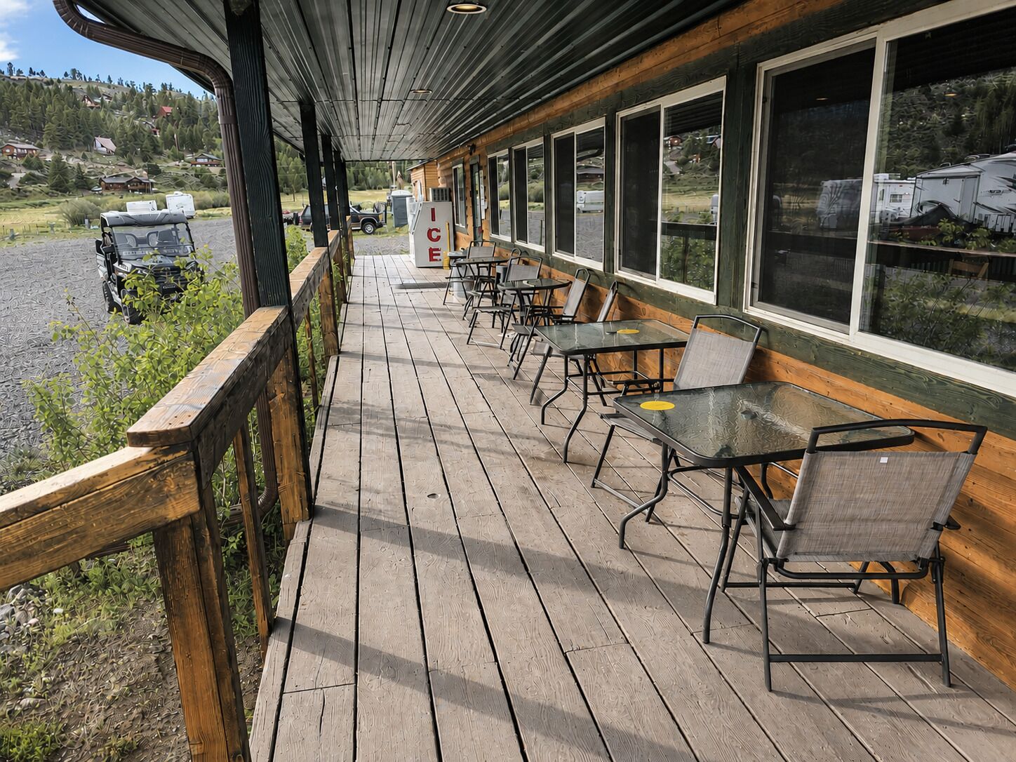 Terraza de madera con asientos exteriores y vistas a un paisaje nevado.
