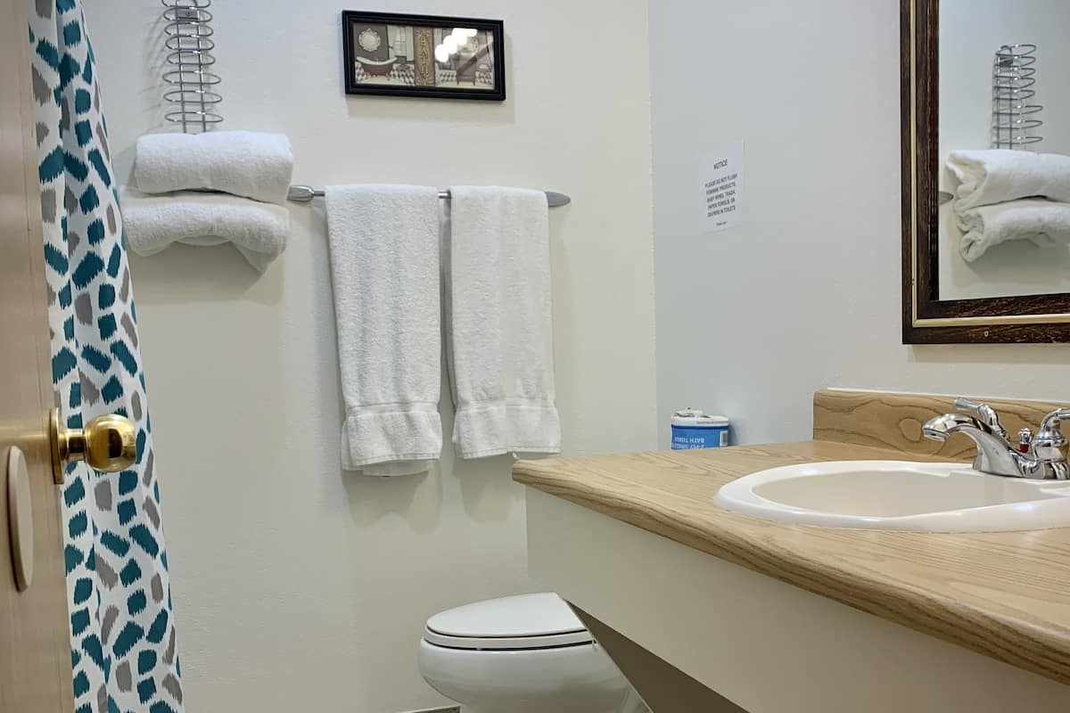 Een bad/douchecombinatie, gratis toiletartikelen, handdoeken, zeep