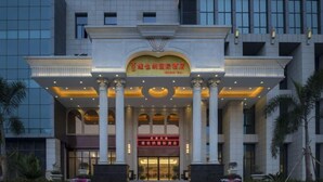 A hotel entrance with a grand archway, columns, and a well-lit facade. - Vienna International Hotel (Danzhou Dingshang Square) (Danzhou)