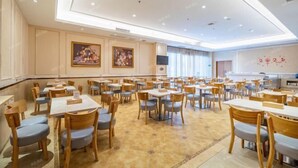 A spacious dining area with multiple tables and chairs, a high ceiling with recessed lighting, and artwork on the walls. - Vienna International Hotel (Danzhou Dingshang Square) (Danzhou)