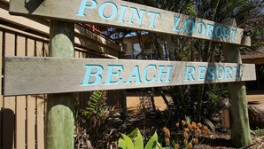 Ein Holzschild mit der Aufschrift 'POINT LOOKOUT BEACH RESORT'.