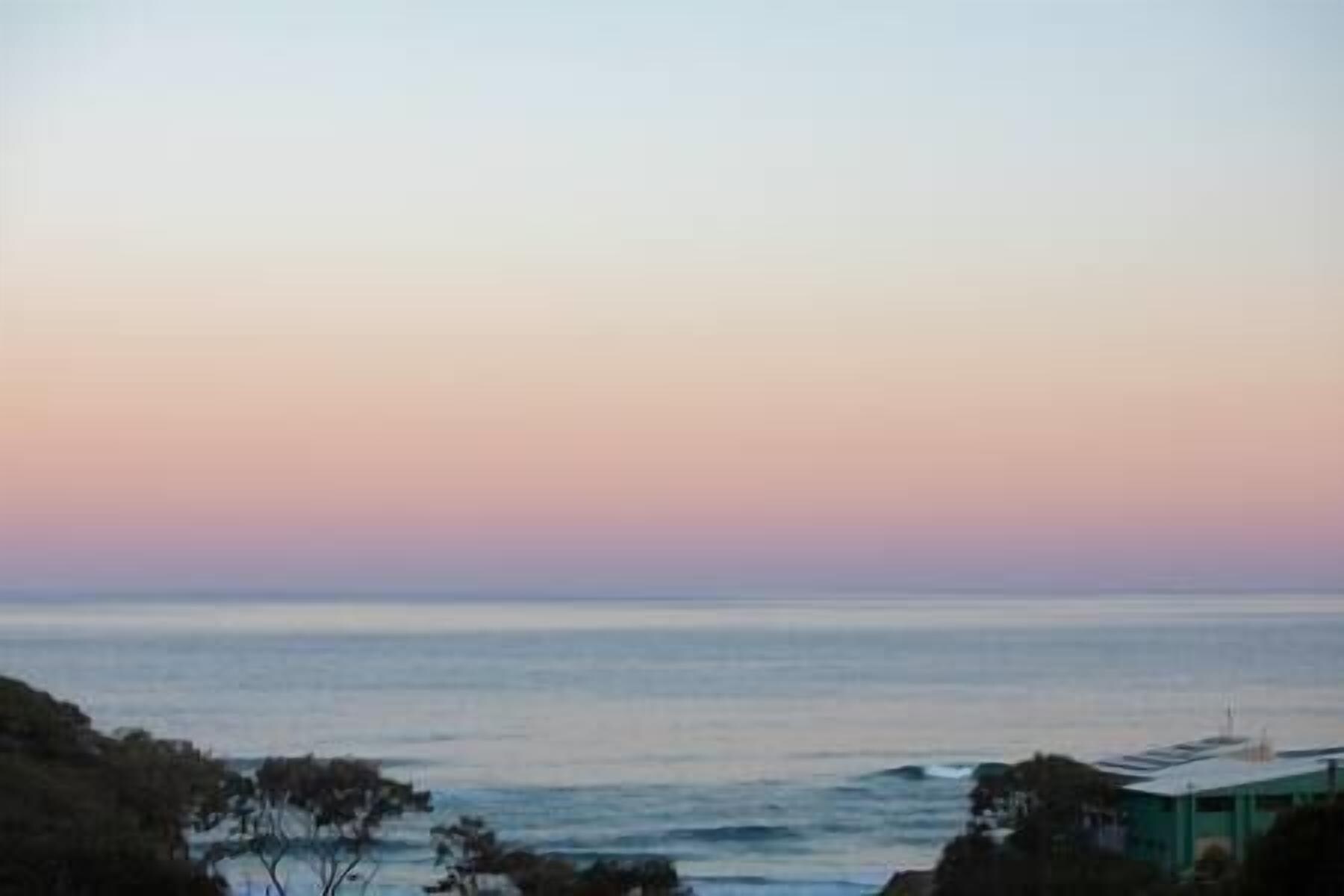 A coastal view with a calm sea and a clear sky.