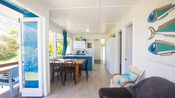 A modern interior with a dining area, kitchen, and living space. - Cabana - One of the only original Straddie beach shacks left standing. (Point Lookout)