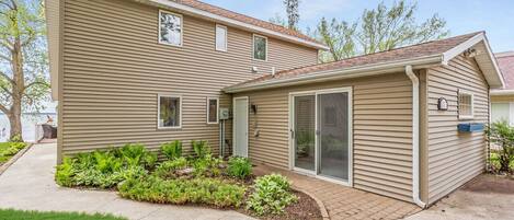 A two-story house with a covered patio, a garage, and a small garden area.