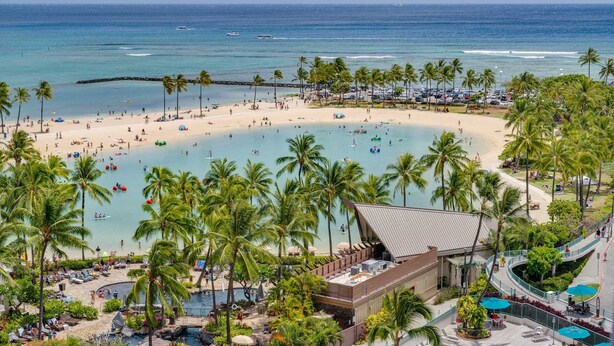 A beach resort with a pool area, palm trees, and a view of the ocean. - Ilikai 1128 Ocean/Lagoon Views / Free Parking / King Bed, Q Sofa Bed (Waikiki)
