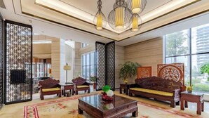 A traditional-style lobby with wooden furniture, a glass coffee table, and decorative screens. - Zhuangzi International Hotel (Mengcheng)