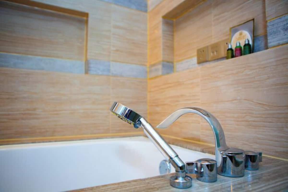 Une salle de bain moderne avec un robinet chromé et une pomme de douche intégrée.