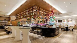 A modern hotel lobby with a central bar area, wooden shelving with various items, and a decorative sculpture. - Zhuangzi International Hotel (Mengcheng)