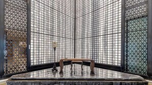 A room with a tiled wall, a wooden bench, and a small table. - Zhuangzi International Hotel (Mengcheng)