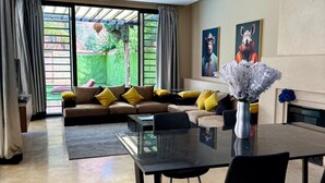 Una sala moderna con un sofá, una mesa de comedor y un ventanal amplio.