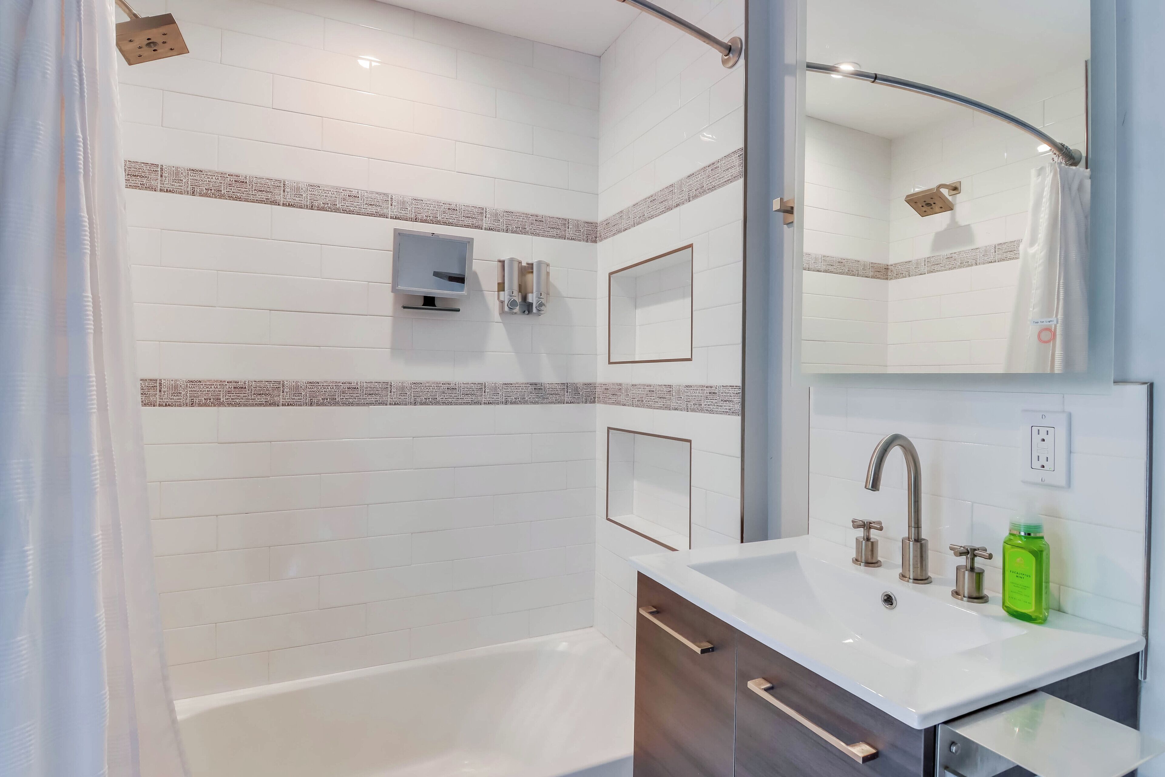 A modern bathroom with a bathtub, a sink with a mirror, and a shower area.