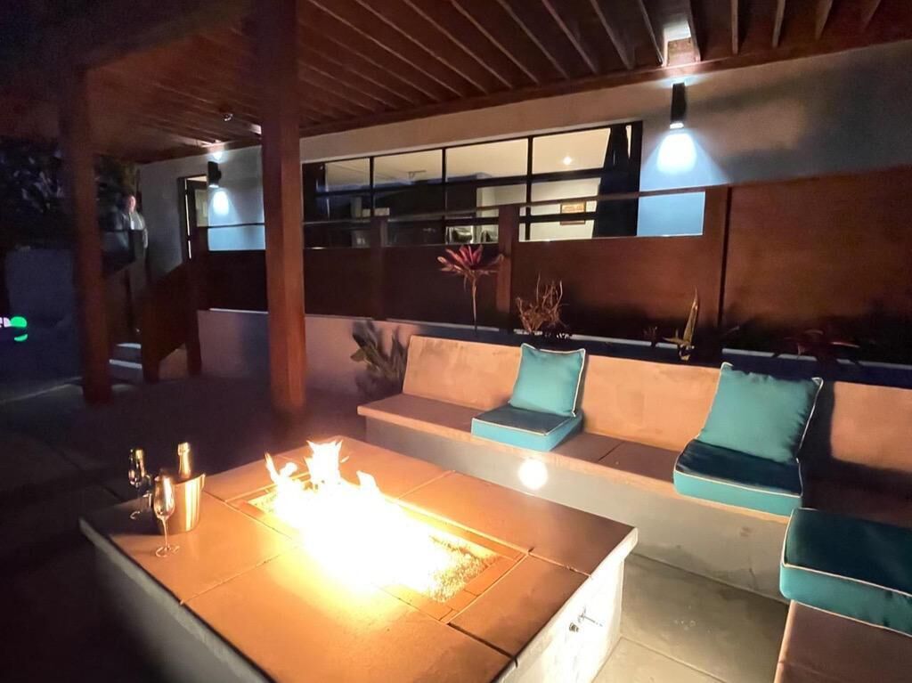 An outdoor seating area with a fire feature, cushioned seating, and a modern design.