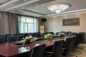 A conference room with a long table, multiple chairs, and a chandelier. - Wanhao Hotel (Hailun)