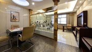 Um saguão de hotel moderno com uma sala de conferências, um painel de vidro e uma área de refeições.