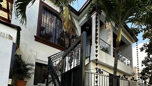 A residential building with a gated entrance, tiled steps, and potted plants. - New Two bedroom apartment, totally equipped with a large covered Patio (Santiago De Los Caballeros)