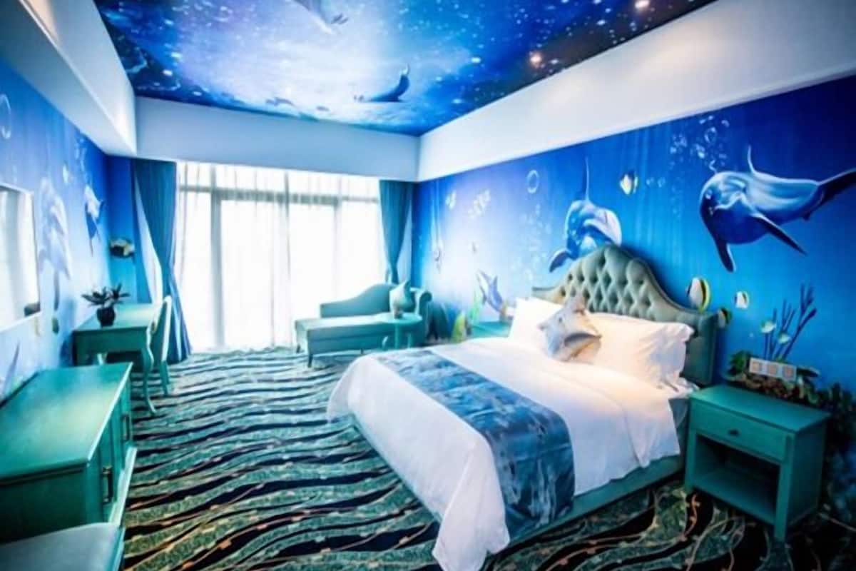 A bedroom with a bed, a desk, a chair, and a window.