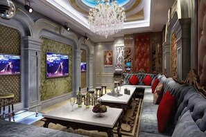 A luxurious interior with a grand chandelier, a plush seating area, and a television screen. - Yuhe Hotel (Jiajiang)