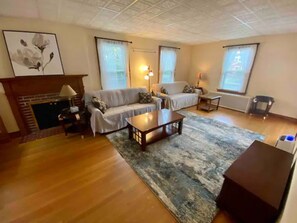 A living room with a fireplace, two sofas, a coffee table, and a rug. - Beautiful 3BR, Cozy House near Downtown Albany (Albany)