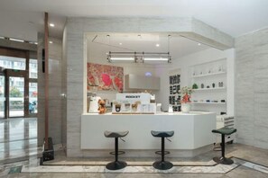 A modern bar area with a white counter, three stools, and a neon sign. - Jia Yue Hotel (Tongxiang)