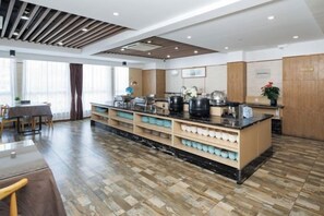A modern kitchen with a central island, built-in appliances, and a dining area with a table and chairs. - Jia Yue Hotel (Tongxiang)