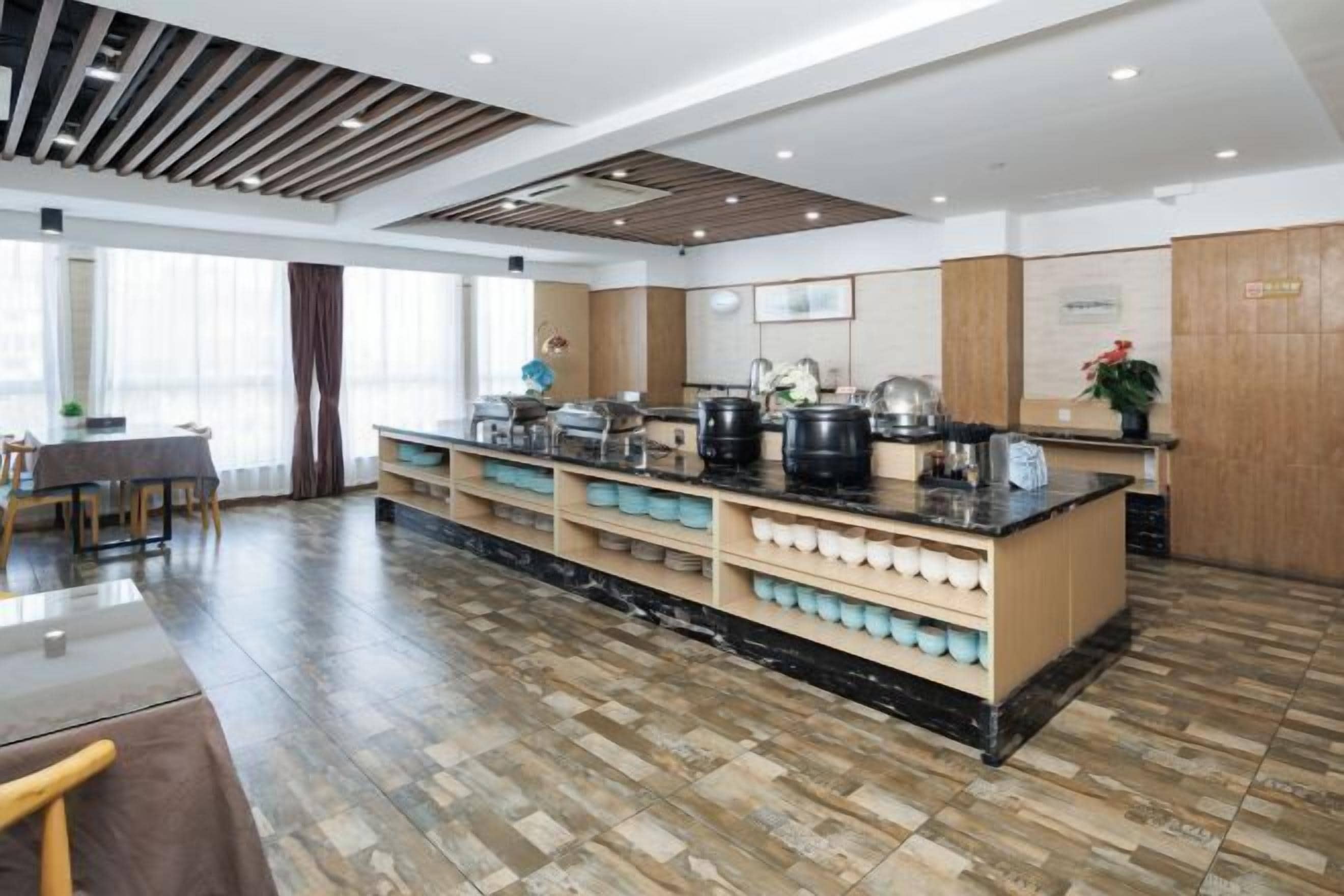 A modern kitchen with a central island, built-in appliances, and a dining area with a table and chairs.