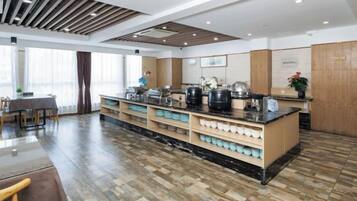 A modern kitchen with a central island, built-in appliances, and a dining area with a table and chairs.