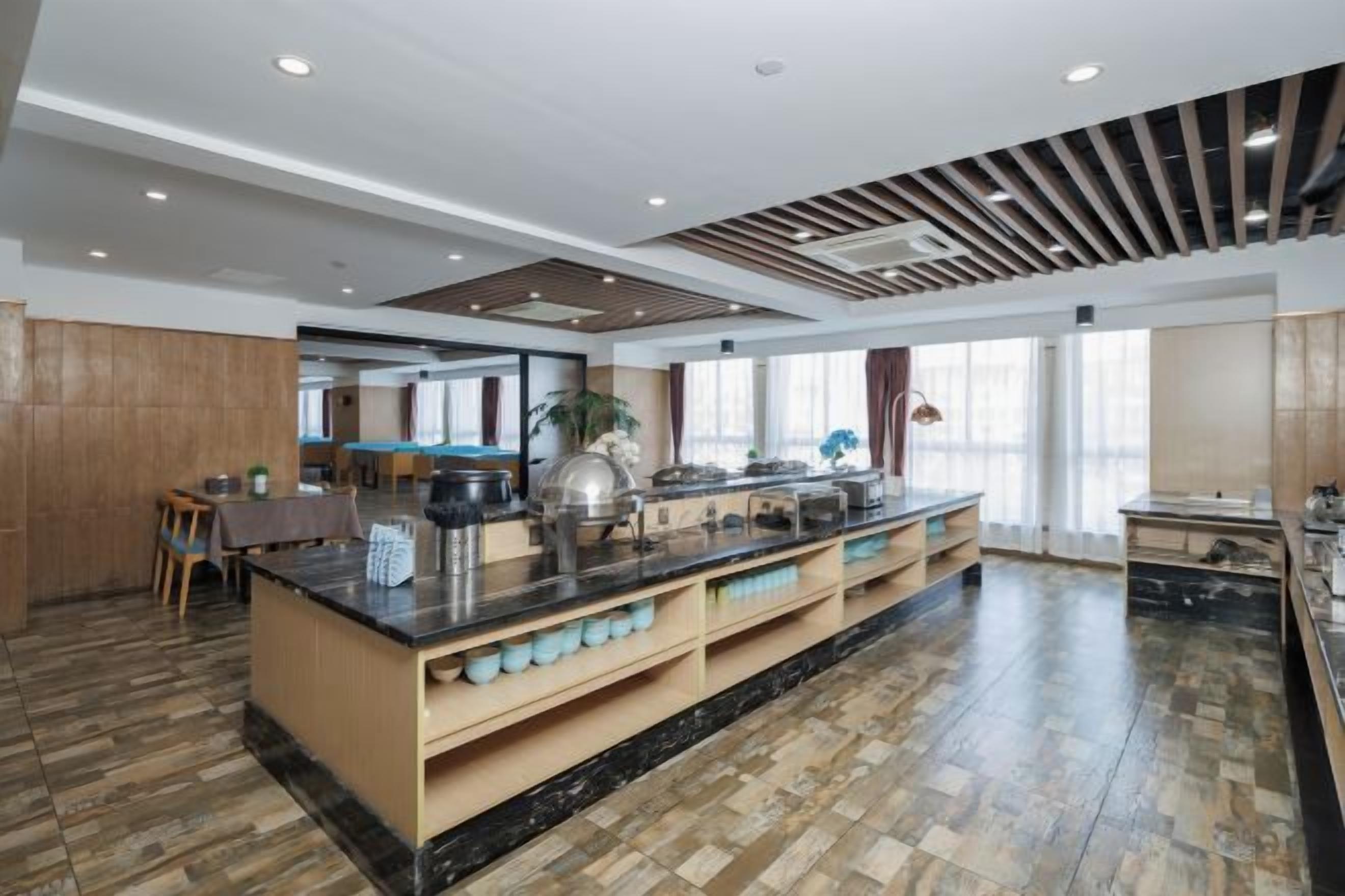Uma cozinha ampla com ilha central, piso de madeira e armários modernos.