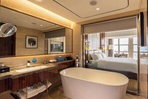 A modern bathroom with a freestanding bathtub, a large mirror, and a vanity with a sink and towel rack. - Clear Lake Hotel (Shanwei)