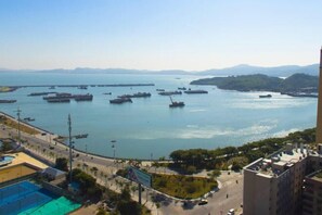 A coastal marina with multiple boats docked, a clear sky, and buildings in the foreground. - Clear Lake Hotel (Shanwei)