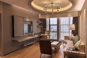 Una sala moderna con un sofá, una mesa de comedor y un televisor montado en la pared.