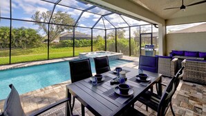 A poolside area with a hot tub, seating, and a grill. - Blue Pearl| Pool | Hot Tub | 3 Bed, 2 Bath (Rotonda West)