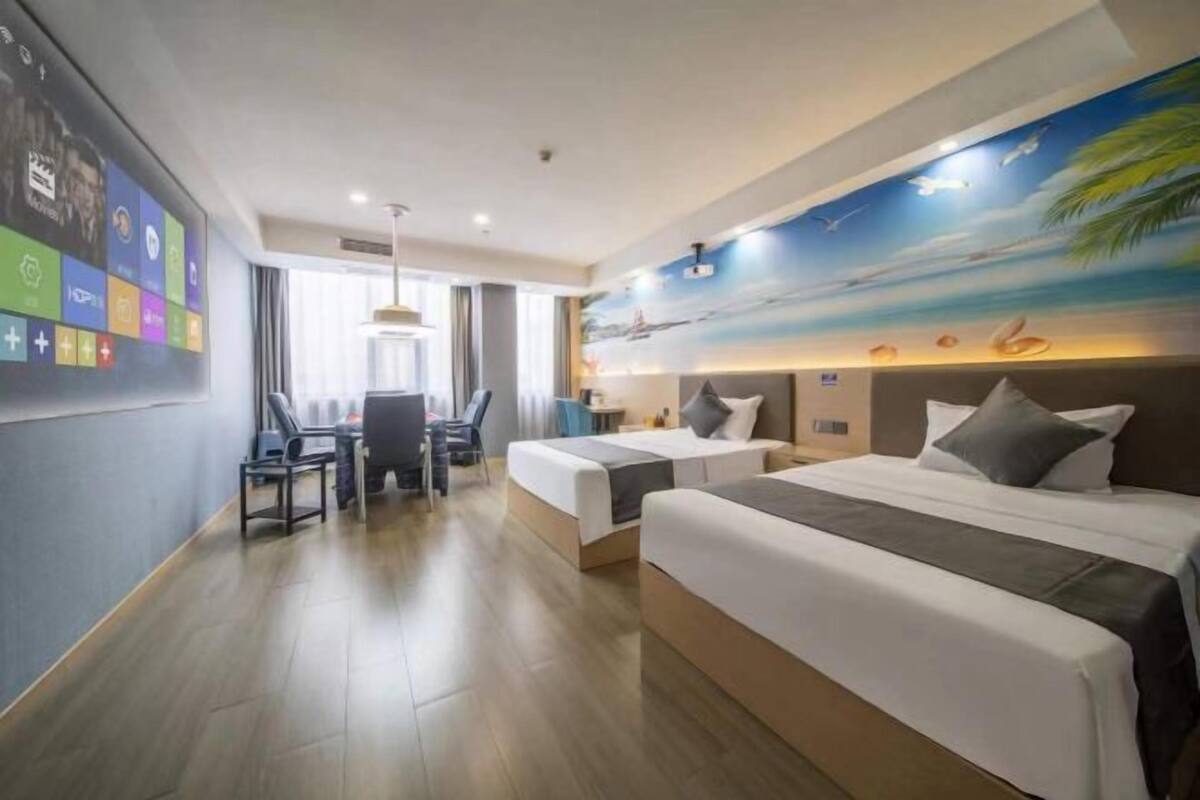 Une chambre d’hôtel avec deux lits, un bureau et une chaise.