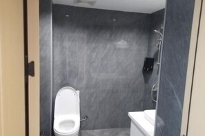 A bathroom with a toilet, a shower, and a sink. - Yijian Meisu Hotel Lijiang (Lijiang Branch) (Yuanjiang)