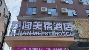 Un hotel con varios pisos, unidades de aire acondicionado en el exterior y un letrero en chino e inglés.